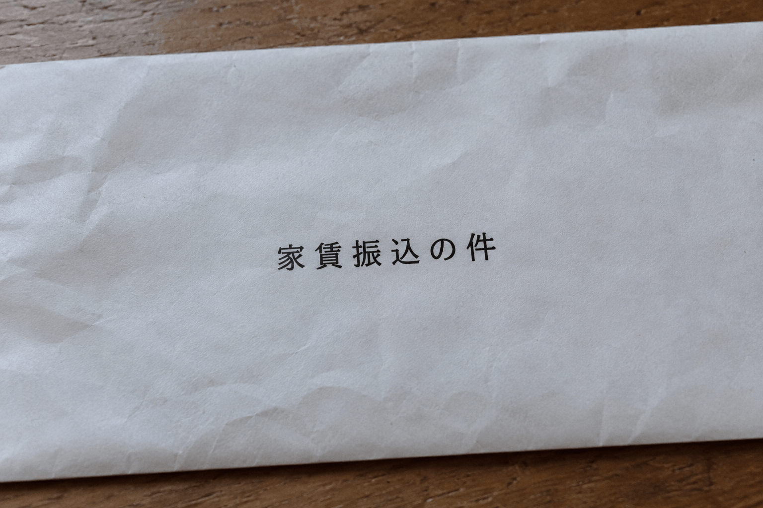 若葉荘の大家提供。白い封筒に印刷された「家賃振込の件」の文字。