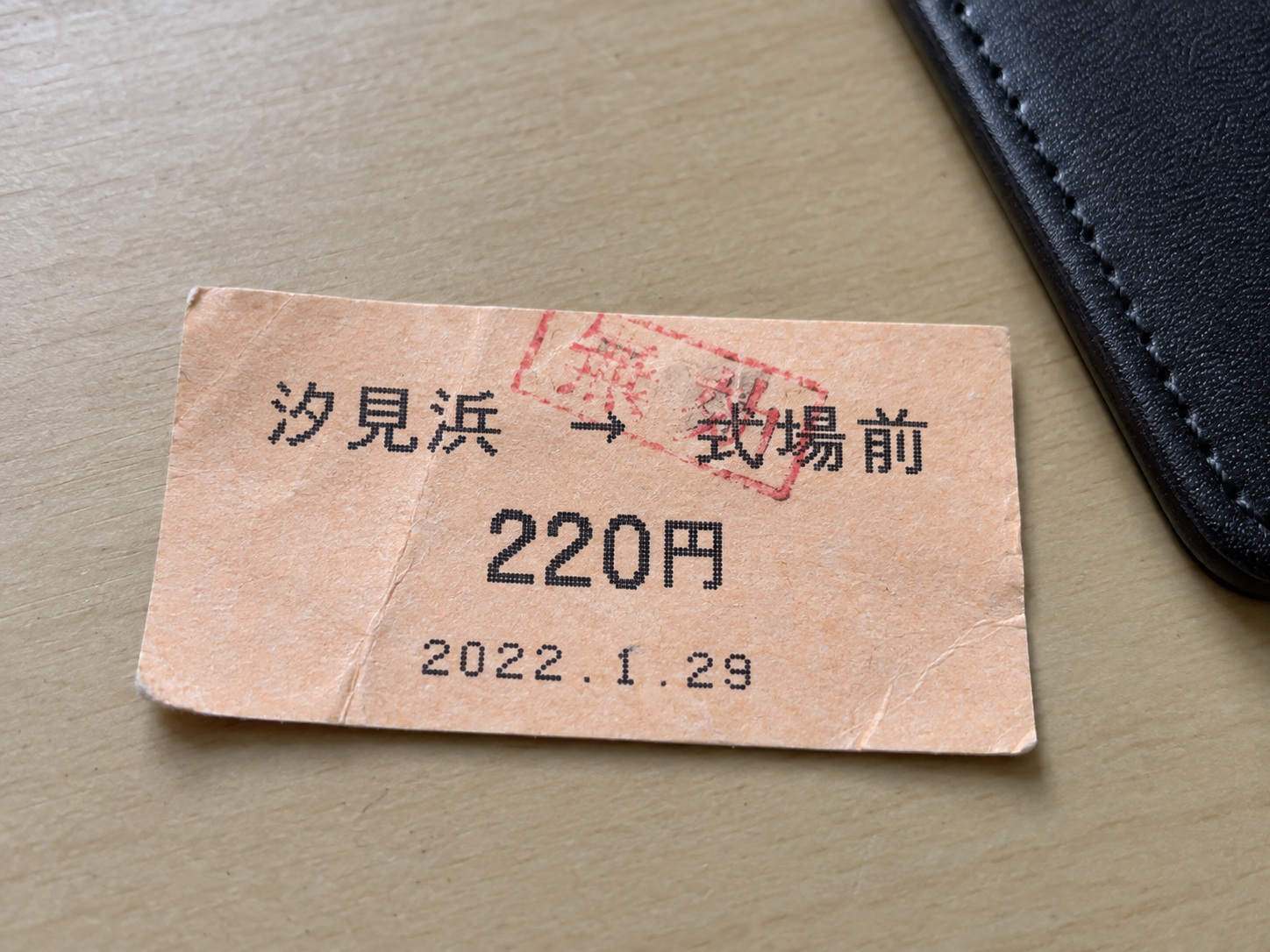 霧島秀一撮影。机に置かれた薄い橙色の切符に、汐見浜から式場前、220円、2022年1月29日と印刷されている。駅名に赤い無効の印が斜めに重なっている。